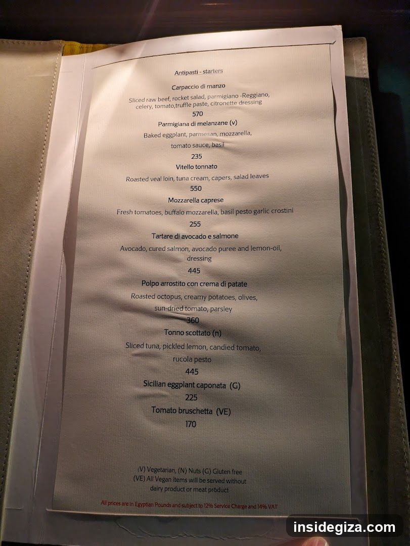 A printed menu page displaying Italian starters with prices in Egyptian Pounds, including Carpaccio di manzo, Parmigiana di melanzane, Vitello tonnato, and others.