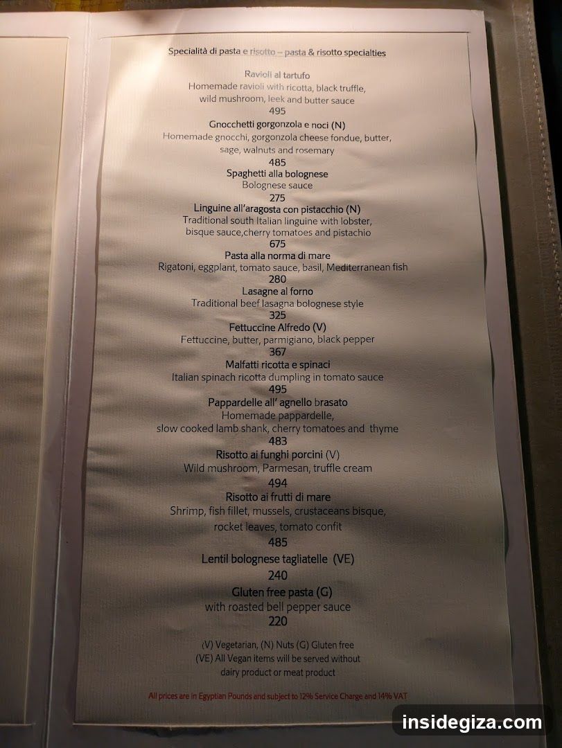 A printed menu page listing Italian pasta and risotto dishes with prices in Egyptian Pounds, including items like Ravioli al tartufo, Gnocchetti gorgonzola e noci, Spaghetti alla bolognese, Pasta alla norma di mare, Lasagne al forno, Fettuccine Alfredo, Malfatti ricotta e spinaci, Pappardelle all'agnello brasato, Risotto ai funghi porcini, Risotto ai frutti di mare, Lentil bolognese tagliatelle, and Gluten free pasta.