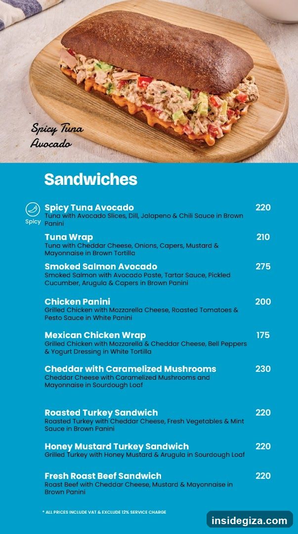 A vibrant blue menu board featuring a photo of Spicy Tuna Avocado sandwich at the top, followed by a list of sandwiches with prices.